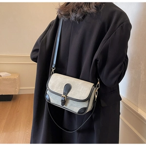 Détail d'un sac bandoulière vintage vert sauge avec passepoil en cuir noir
