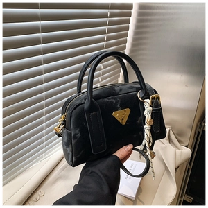 Détail d'un sac oreiller vintage à motif marbré avec plaque triangle dorée