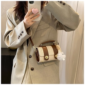 Detail of herringbone Boston bag featuring brown leather trim and golden twist lock