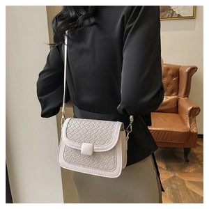 Detail showing the elegant woven texture and side layers of the beige flap square bag
