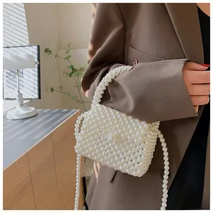Detailed shot of white handmade pearl beaded crossbody bag with elegant handle