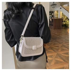 Detail showing woven texture and smooth leather strap of the stylish beige crossbody bag