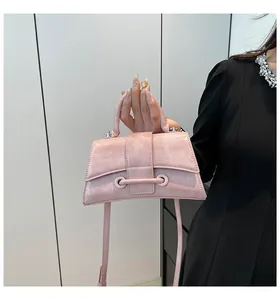 Detailed view of pink hourglass handbag with patent wrinkled texture and curved base