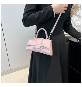Detail view of pink hourglass handbag with glossy texture and metal eyelet clasp design