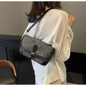 Vue latérale d'un sac porté épaule vintage en toile grise et cuir noir raffiné