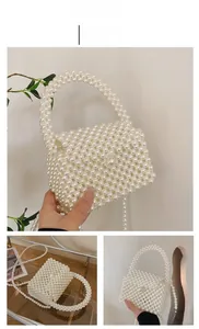 Close-up of white handmade pearl beaded crossbody bag with elegant foldover flap detail