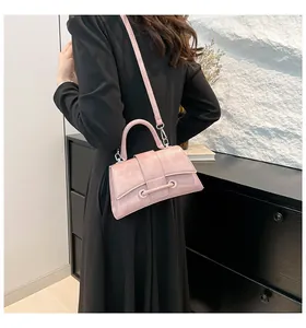 Pink hourglass handbag with glossy finish shown in hand-carry and crossbody style