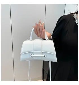 Detailed view of the signature curved base and handle of a white hourglass handbag