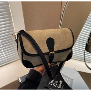 Détail du sac bandoulière en toile beige avec bordure en cuir noir et boucle dorée