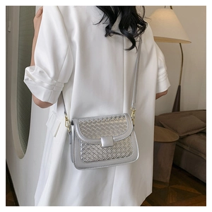Silver woven crossbody bag detail showing metallic texture and square buckle on shoulder strap