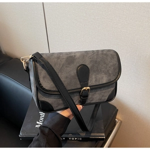 Détail du sac bandoulière en denim gris avec garniture en cuir noir et boucle dorée