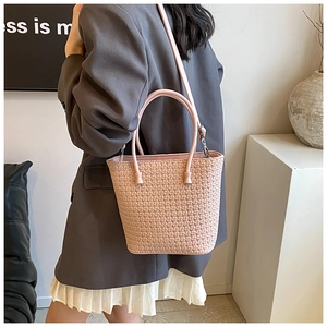 Pink woven tote bag showing adjustable shoulder strap and round handle details