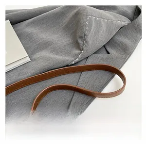 Close-up of brown litchi textured leather shoulder strap with adjustable holes