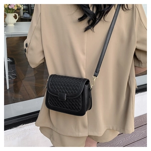 Detailed woven texture of a black crossbody bag shown on a model for daily wear style