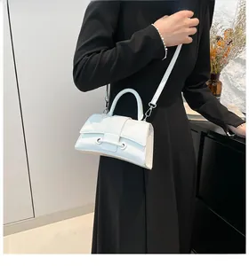 White glossy patent leather hourglass handbag with detachable strap on model