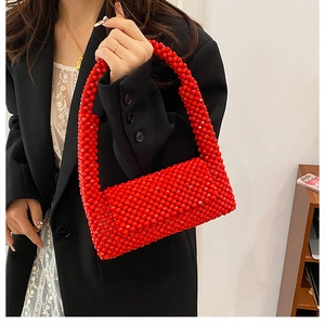 Detail of red handmade beaded handbag with woven round pearls texture and retro style