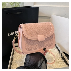 Detailed close-up of pink woven flap bag featuring a square buckle and metallic hardware