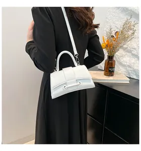 Close-up of white hourglass handbag with top handle and fine shoulder strap for women
