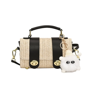 Fashionable woven cylinder handbag with black leather trim and cute monster keychain charm