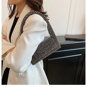 Detailed view of a black handmade beaded shoulder bag with French retro style texture