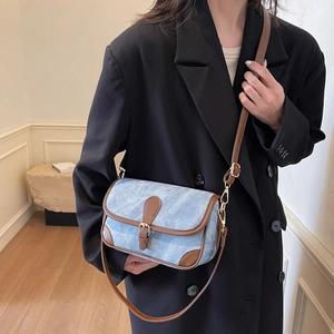 Sac bandoulière en denim bleu rétro avec garniture en cuir brun et boucle dorée