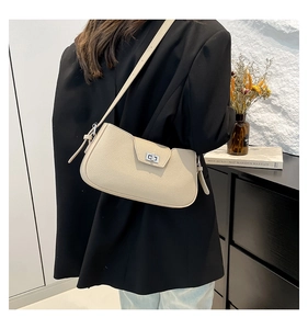 Detail of minimalist cream shoulder bag with pebble grain leather and silver twist lock