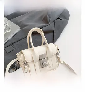 Détail du mini sac bandoulière crème avec fermoir métallique argenté et texture cuir