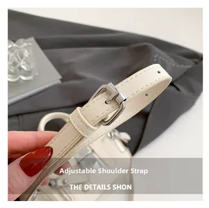 Vue détaillée de la bandoulière réglable avec boucle en métal argenté du sac beige