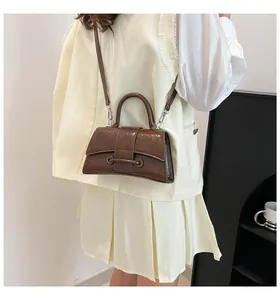 Close-up of a dark brown hourglass handbag with glossy finish and silver hardware details