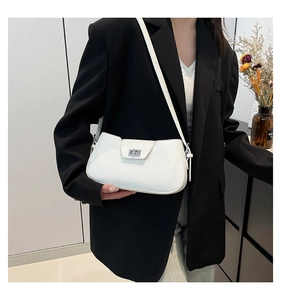Detailed view of white lychee leather texture and silver metal turn-lock on the bag
