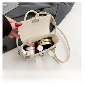 Vue intérieure d'un mini sac à rabat crème montrant la capacité pour le maquillage