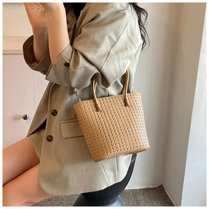 Detail of retro woven tote bag featuring round handles and leather shoulder strap