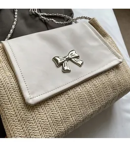 Détail du sac bandoulière en paille avec rabat en cuir et boucle en métal argenté