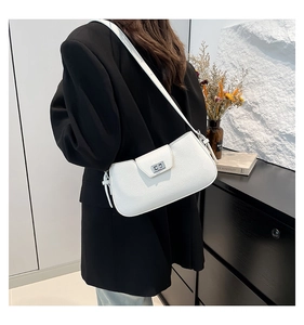 Close-up of white lychee textured shoulder bag with silver lock on a female model
