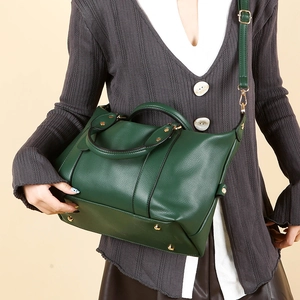 Sac polochon en cuir grainé vert foncé avec poignées et bandoulière réglable chic