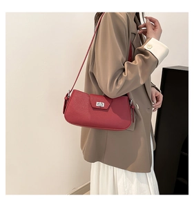 Detail of red pebbled leather shoulder bag with silver turn-lock and slim strap