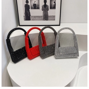 Row of beaded handbags in black red silver and grey colors on a modern art display
