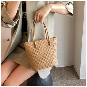 Detail of hand-woven straw tote bag texture and elegant trapezoidal structure