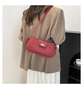 Detail of red lychee pattern leather shoulder bag with silver rectangular swivel clasp