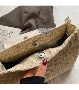 Détail de la fermeture magnétique en métal sur un sac à main en paille tressée