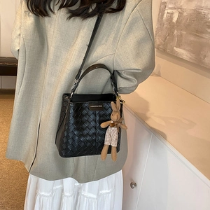 Chic black woven bucket bag with long strap and cute brown rabbit plush pendant accessory