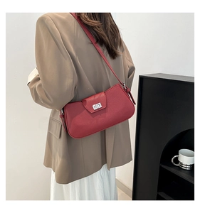 Detail of red pebbled leather shoulder bag with silver turn-lock and minimalist design