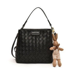 Chic black woven bucket bag with fashion label and brown knitted rabbit charm accessory