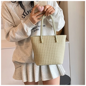 Close-up of light green woven texture tote bag with stylish knot handle detail