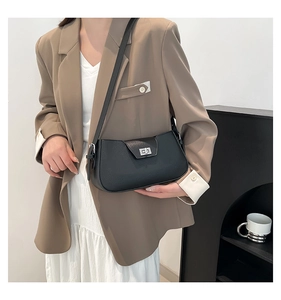 Close-up of black litchi pattern leather shoulder bag with silver metal twist lock