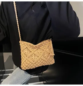Detail of hand-woven beige bucket bag with diamond knit texture and tassel charm