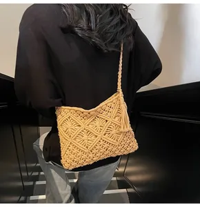 Detail of bohemian crochet bucket bag with hollow geometric pattern and side fringe