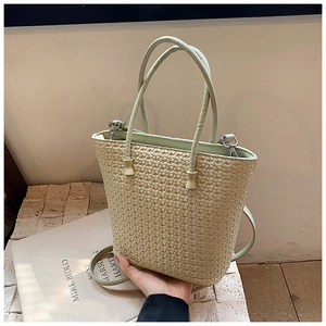 Detail of woven texture on minimalist beige shoulder bag with metal strap connectors