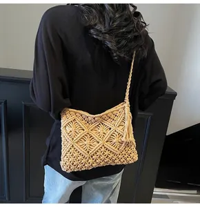Close-up of beige knitted bucket bag with diamond hollow patterns and tassel detail