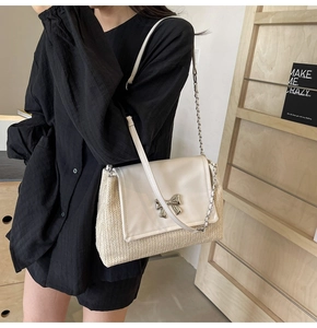 Détail du sac à bandoulière en paille et cuir crème avec une boucle de nœud argenté chic